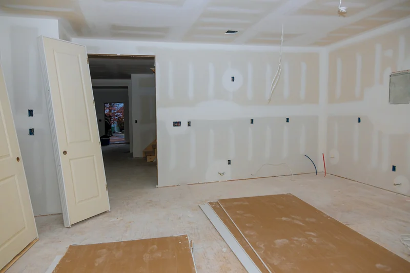 Taped room with doors and cardboard laid over the floor