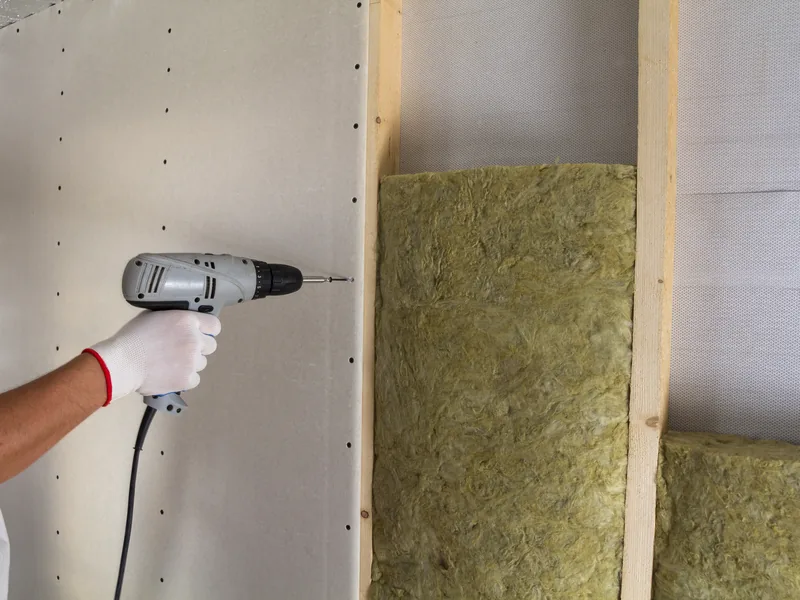 Insulation batts set in an open wall cavity before board