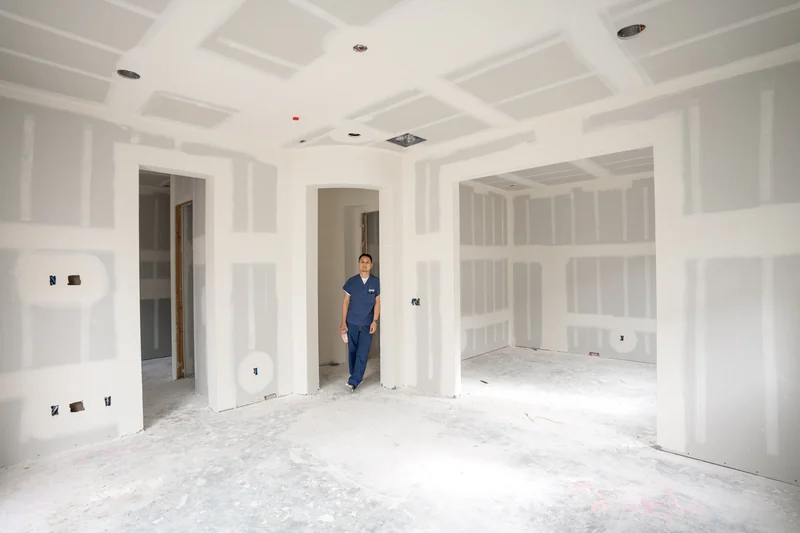 Worker standing in a large unfinished interior with the walls boarded