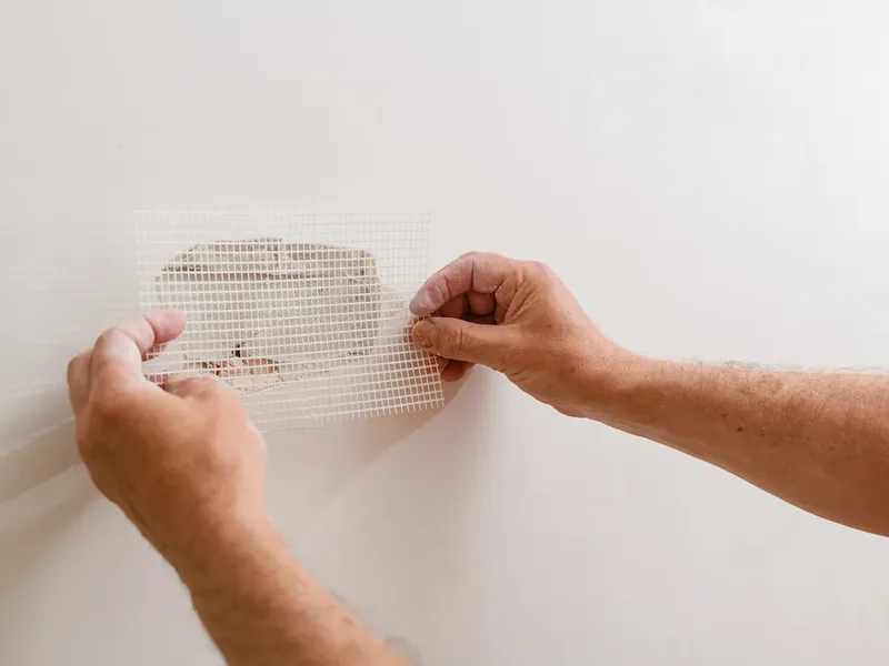 Mesh patch set over a wall hole during a fast-response repair