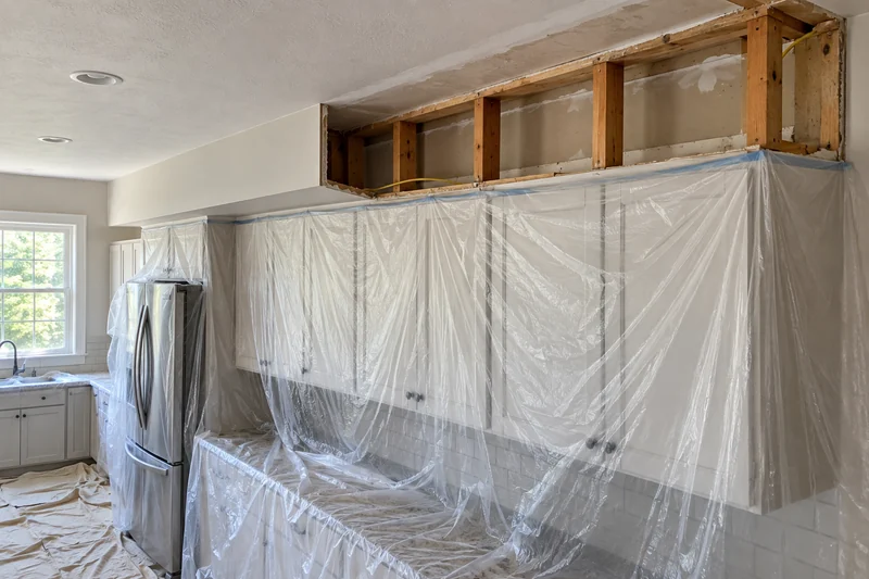 Kitchen soffit half removed, open framing and the scar where the box was